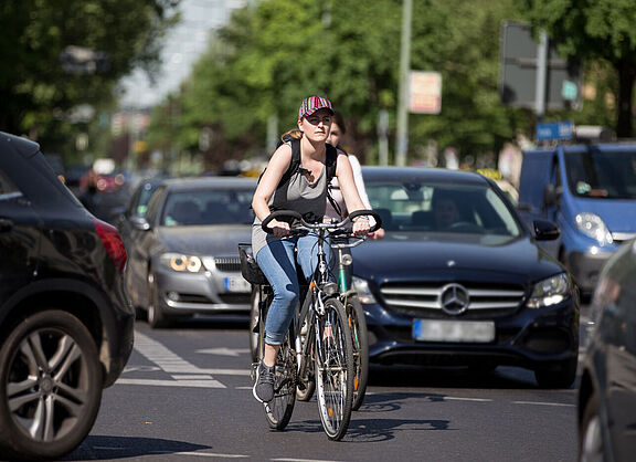 Radfahrerin zwischen Autos